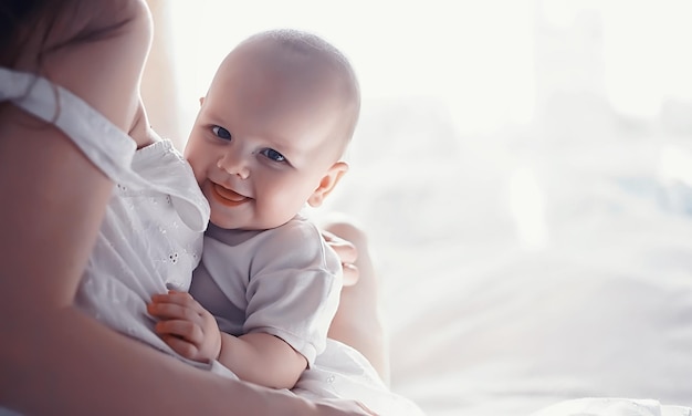 Maternity concept A young mother feeds her little baby First lure and breastfeeding Family in white clothes