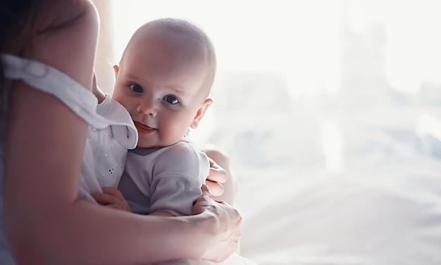 Maternity concept. A young mother feeds her little baby. First lure and breastfeeding. Large family in white clothes.