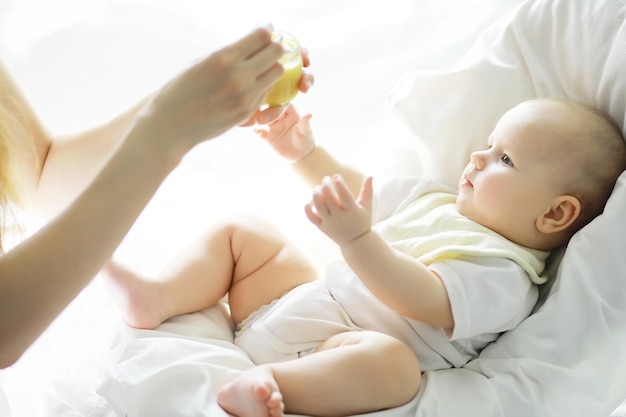 Maternity concept A young mother feeds her little baby First lure and breastfeeding Large family in white clothes