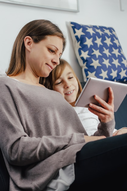 Mather and daughter looking pictures on a tablet