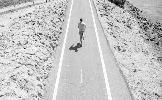 Mature athletic man running on road outdoor marathon