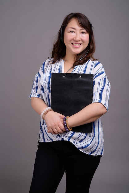 mature beautiful Asian businesswoman holding folder