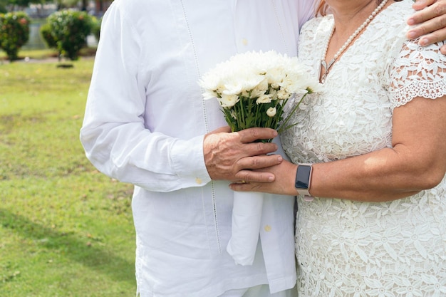 Mature bride holds a beautiful bouquet of white flowers Newlyweds on their wedding day