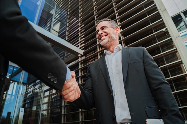 Photo mature business man giving a handshake to seal an agreement after the negotiation middle aged