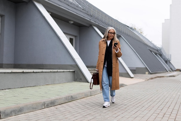 Mature business woman walking talking on the cell phone