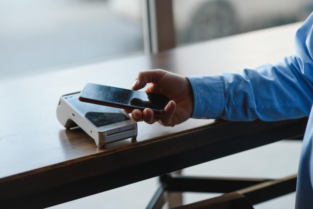 Photo mature businessman paying with contactless credit card with nfc technology