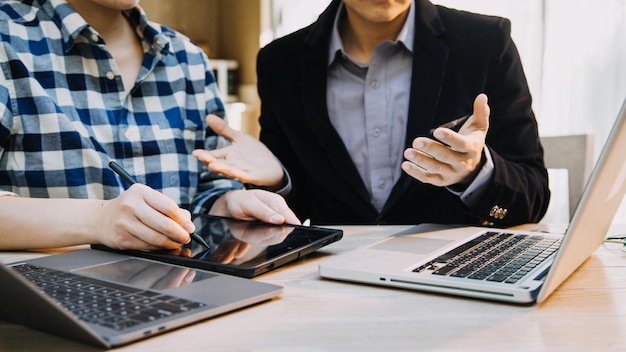 Mature businessman using a digital tablet to discuss information with a younger colleague