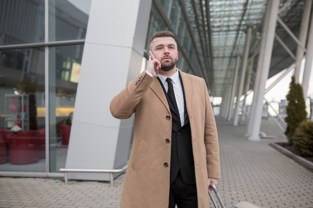 Mature Businessman with beard in black suit and coat posing