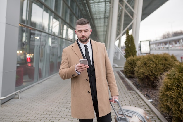 Mature Businessman with beard in black suit and coat posing