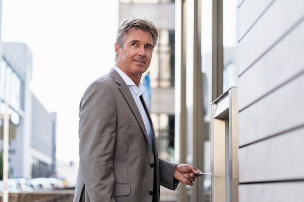 Mature businessman withdrawing money at an ATM