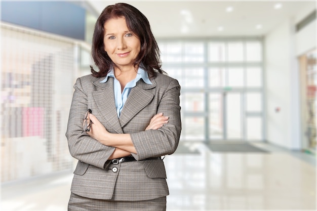 Mature businesswoman wearing formal suit on background