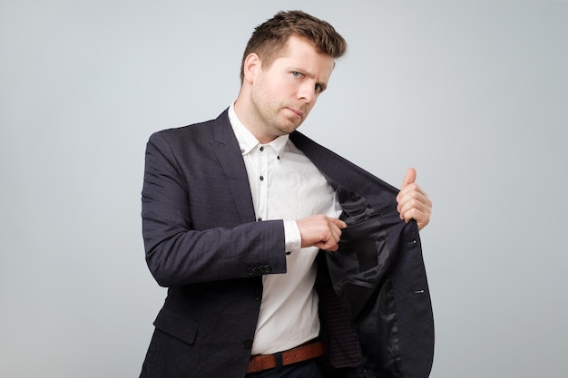 Mature caucasian business man hiding money in pocket