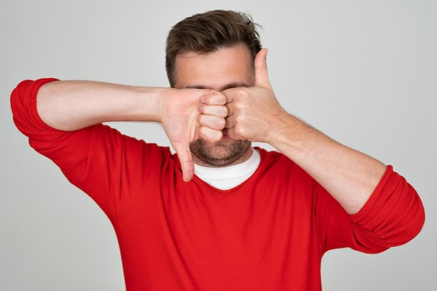 Mature caucasian man making goodbad sign showing thumb up and down