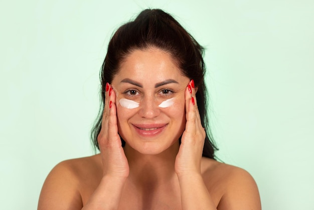 Mature Caucasian woman applying face cream skin care product age 30 to 40