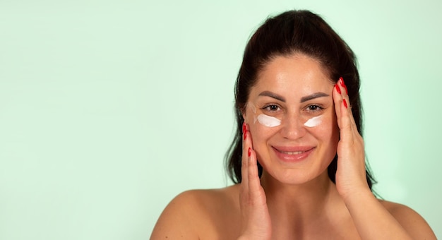 Mature Caucasian woman applying face cream skin care product age 30 to 40