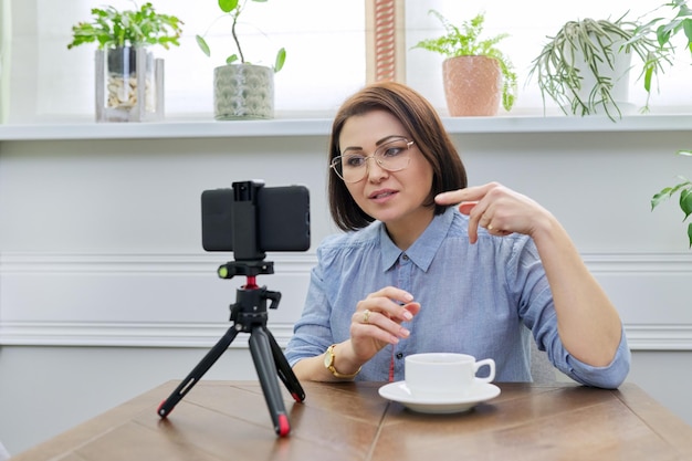 Mature confident woman blogger recording video stream vlog