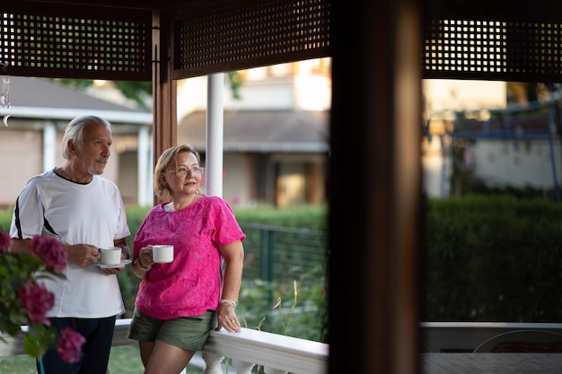 Mature couple drinking coffee on porch Two senior man and woman drinking coffee and smiling or discussing future plan after retire Retirement concept