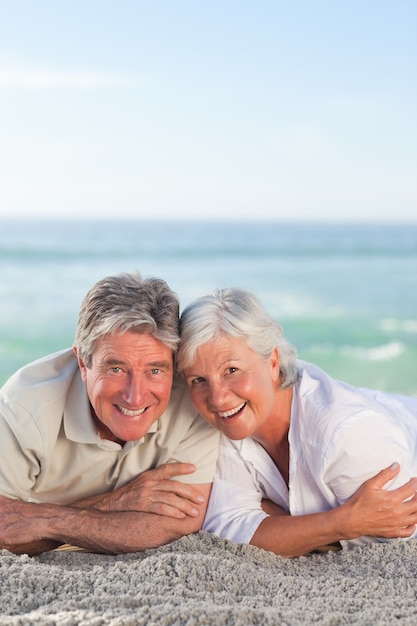 Mature couple lying down on the beach