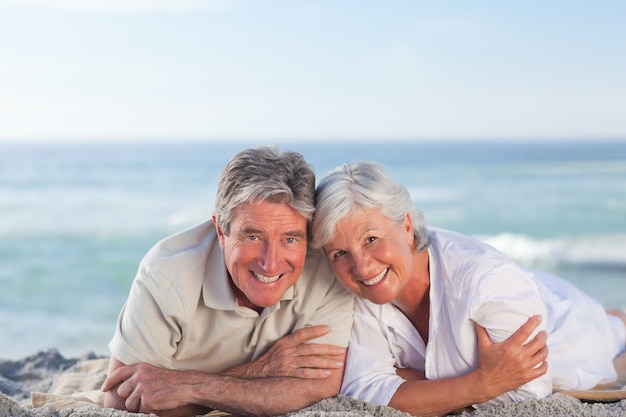 Mature couple lying down on the beach