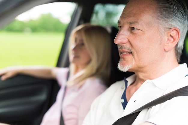 Mature couple traveling in their car