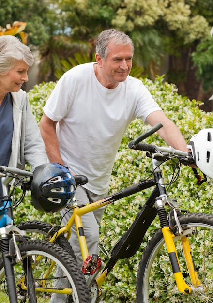 Mature couple walking with their bikes