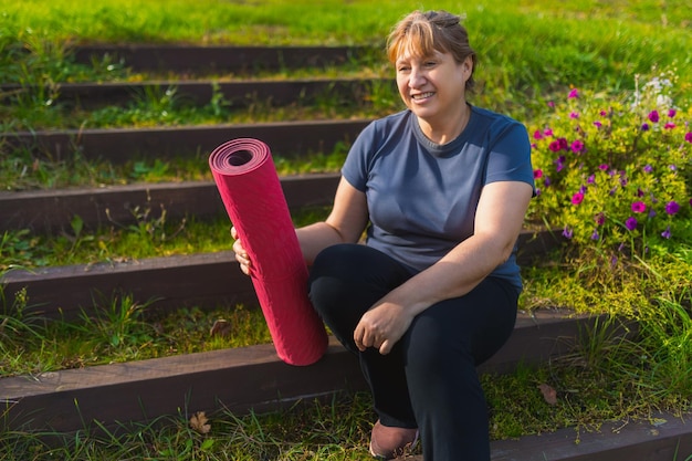 Mature Female On Outdoor Yoga Retreat Walking Along Path Through Campsite