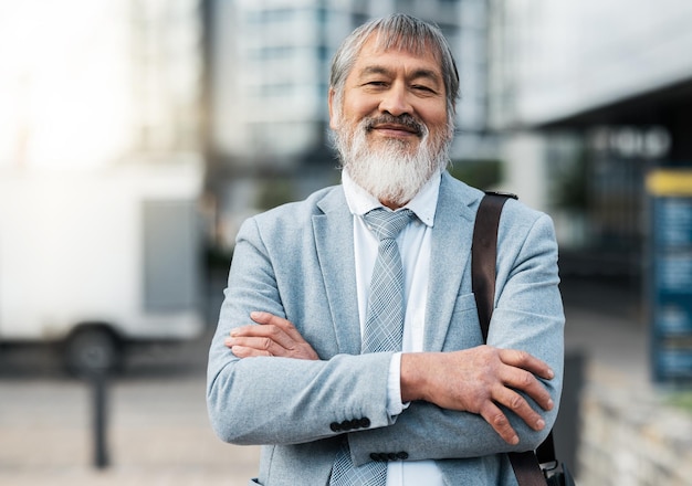 Mature Japanese businessman arms crossed or city travel by office building street or public transport station Portrait smile or happy corporate manager asian ceo or leadership with success goals