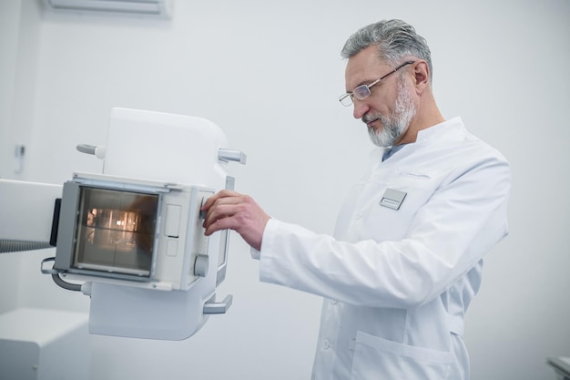 Mature male doctor looking busy at work