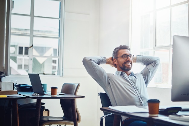 Mature man business and break at desk for stretching productivity or done with project in office Relax computer and male employee with arms behind head for satisfied happiness or achievement