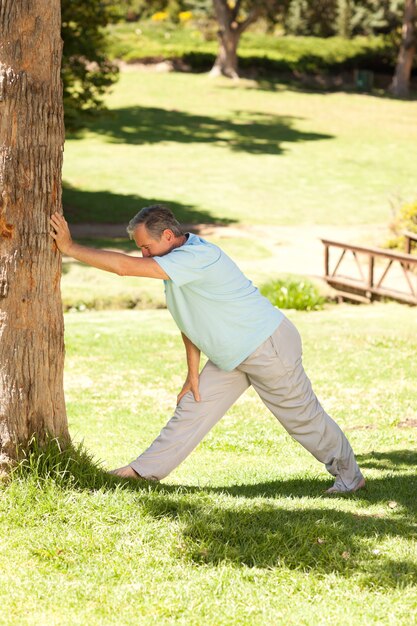 Mature man doing his streches in the park