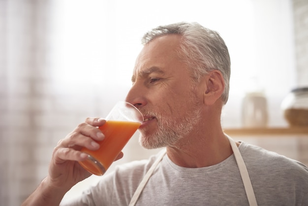 Mature Man Drinks Freshly Squeezed Orange Juice.