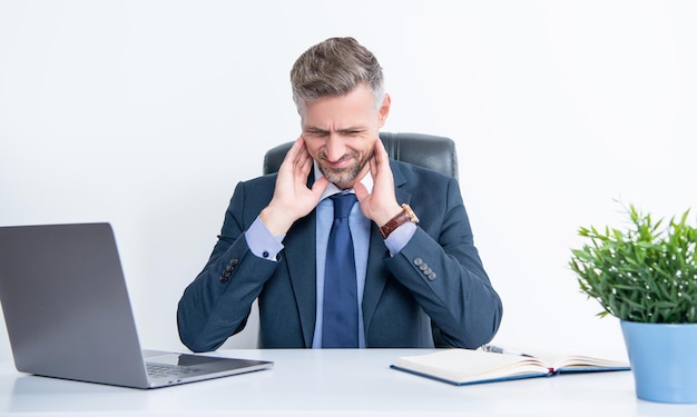 Mature man sitting in business office having sore throat