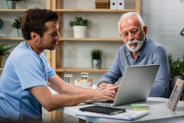 Mature man using a computer with his doctor while having consultations about his medical condition