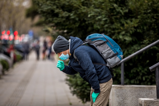 Mature Man Wear Face Mask And Coughing While Standing In The Town.