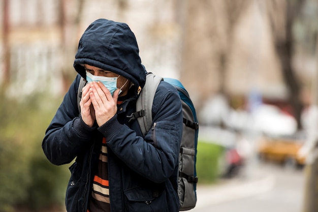 Mature Man Wear Face Mask And Coughing While Standing In The Town