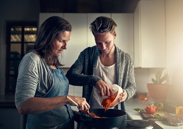 Photo mature mother and son with vegetables in kitchen for bonding support or helping with cooking for dinner family woman or man in home with preparation for healthy meal nutrition or hungry in house