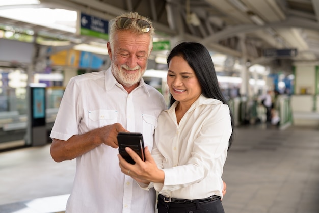 Mature multi-ethnic couple happy and in love while exploring the city of Bangkok