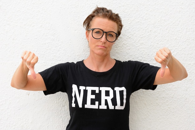 Mature nerd woman wearing big eyeglasses and standing isolated