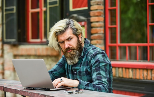 Mature student working on computer go shopping on cyber monday bearded man hipster in cafe with laptop online distant education hipster inspired to work agile business Modern school