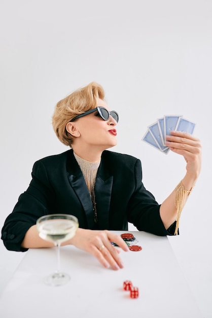 mature stylish woman in black tuxedo and sunglasses in casino Gambling fashion poker face hobby