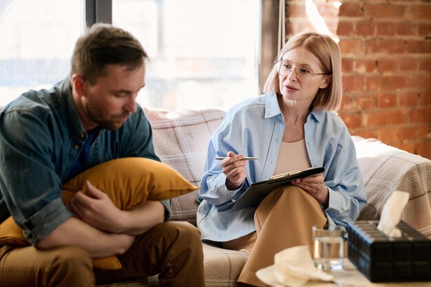 Mature therapist giving an advice to her patient during their session at office