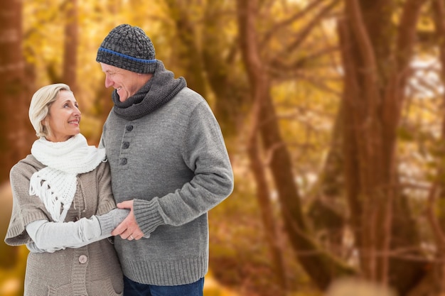 Mature winter couple against tranquil autumn scene in forest