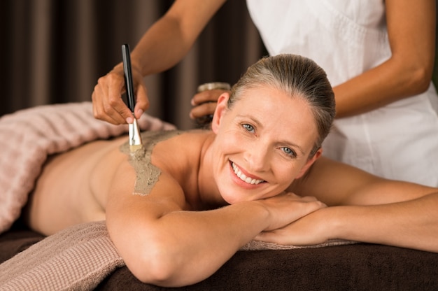 Mature woman enjoying mud massage