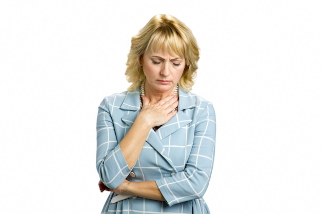 Photo mature woman feeling sore throat. unhappy middle aged woman putting hand near throat isolated on white.