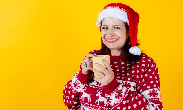 Mature woman laying with a traditional Christmas mug. santa claus hat