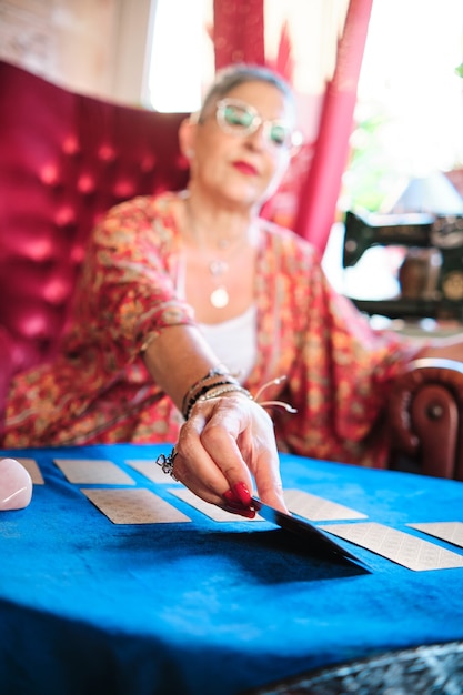 A mature woman ready to reveal a card that will tell the future - risk concept