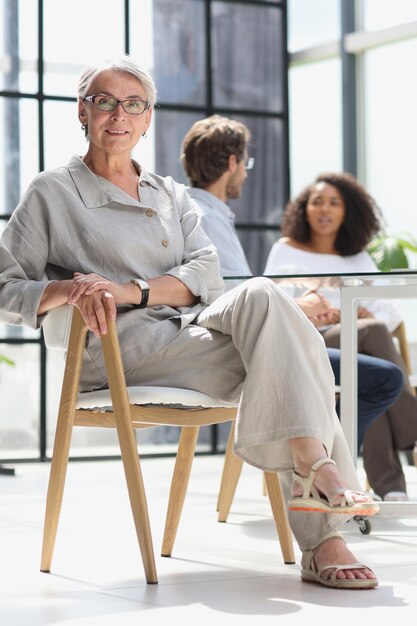 Mature woman sitting with laptop looking at camera