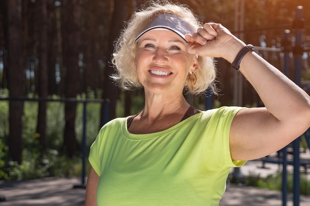 Mature woman in white cap looks at sun smiling closeup