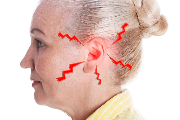 Mature woman with hearing problem on white background