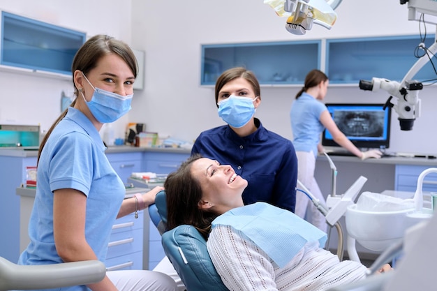 Mature womans visit to the dental clinic. Dental examination and treatment, patient and doctor talking. Medicine, dentistry and health care concept